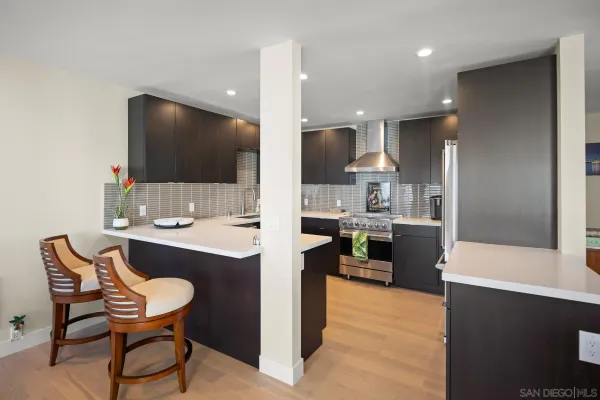 a kitchen with stainless steel appliances kitchen island granite countertop a sink and a refrigerator