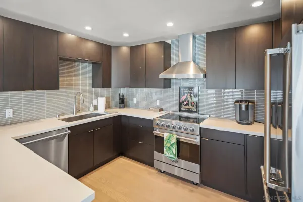 a kitchen with kitchen island granite countertop a sink stainless steel appliances and cabinets