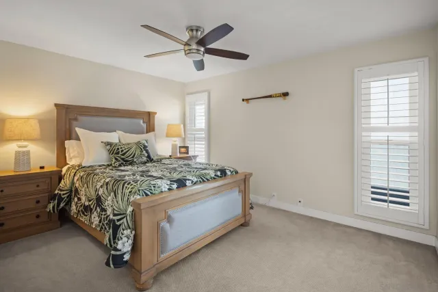 a bed sitting in a bedroom next to a window and a chandelier