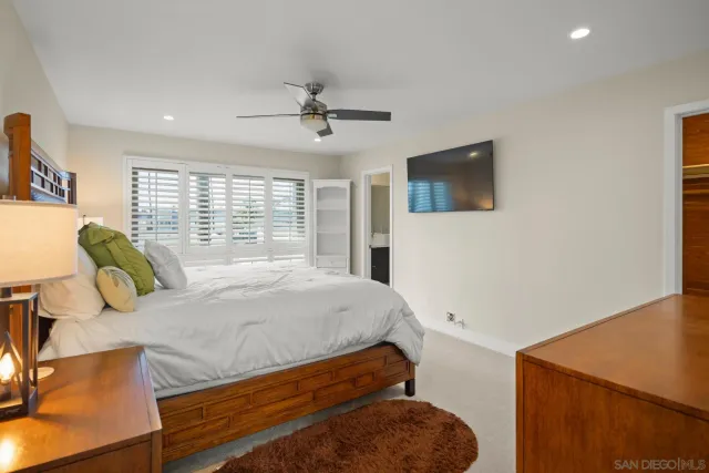 a bedroom with a bed and ceiling fan