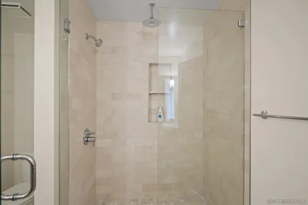 a bathroom with a granite countertop shower sink vanity and toilet