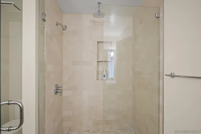 a bathroom with a granite countertop shower sink vanity and toilet