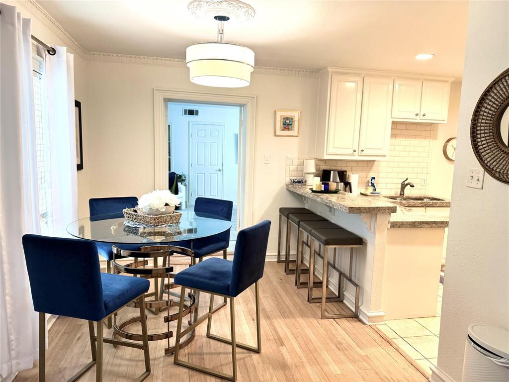 4538 Roland Avenue, Unit 4 Highland Park, TX 75219 - Photo 5 of 9 a kitchen with a table chairs stove and cabinets
