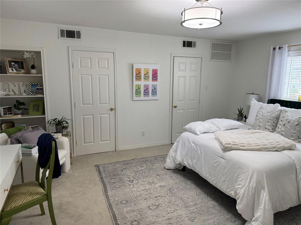 4538 Roland Avenue, Unit 4 Highland Park, TX 75219 - Photo 6 of 9 a bedroom with a bed and a chandelier