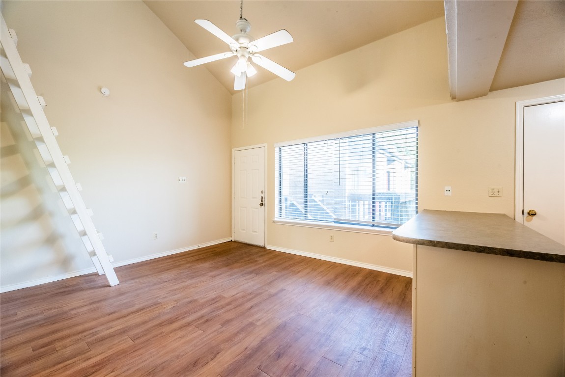 601 Nelray Boulevard, Unit 5 Austin, TX 78751 - Photo 4 of 13 Unfurnished living room featuring light wood-style flooring, high vaulted ceiling, and ceiling fan