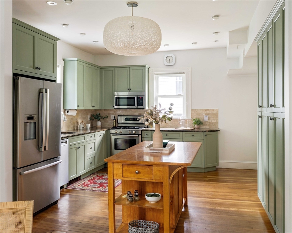 52 Walter Street Boston, MA 02131 - Photo 11 of 31 a kitchen with stainless steel appliances granite countertop a refrigerator a stove and a wooden floors