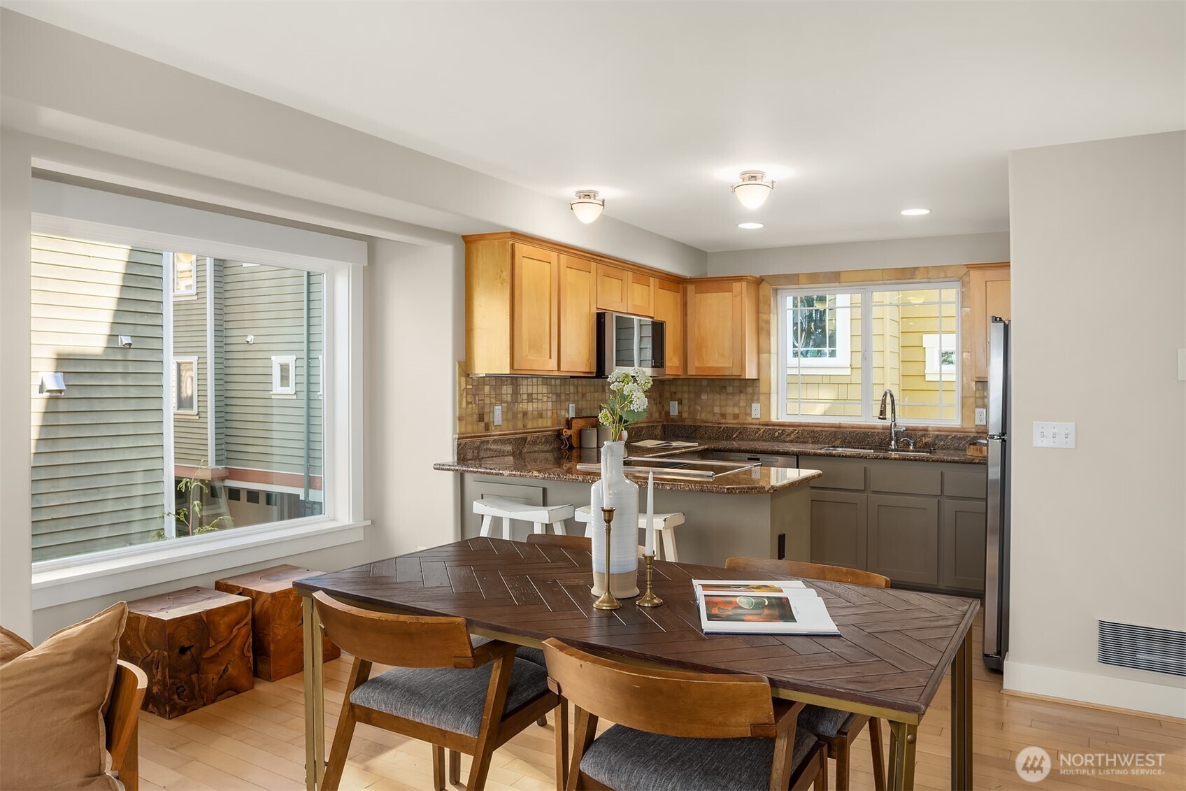 739 North 94th Street, Unit B Seattle, WA 98103 - Photo 25 of 39 a workspace with kitchen island granite countertop wooden floor dining table and chairs