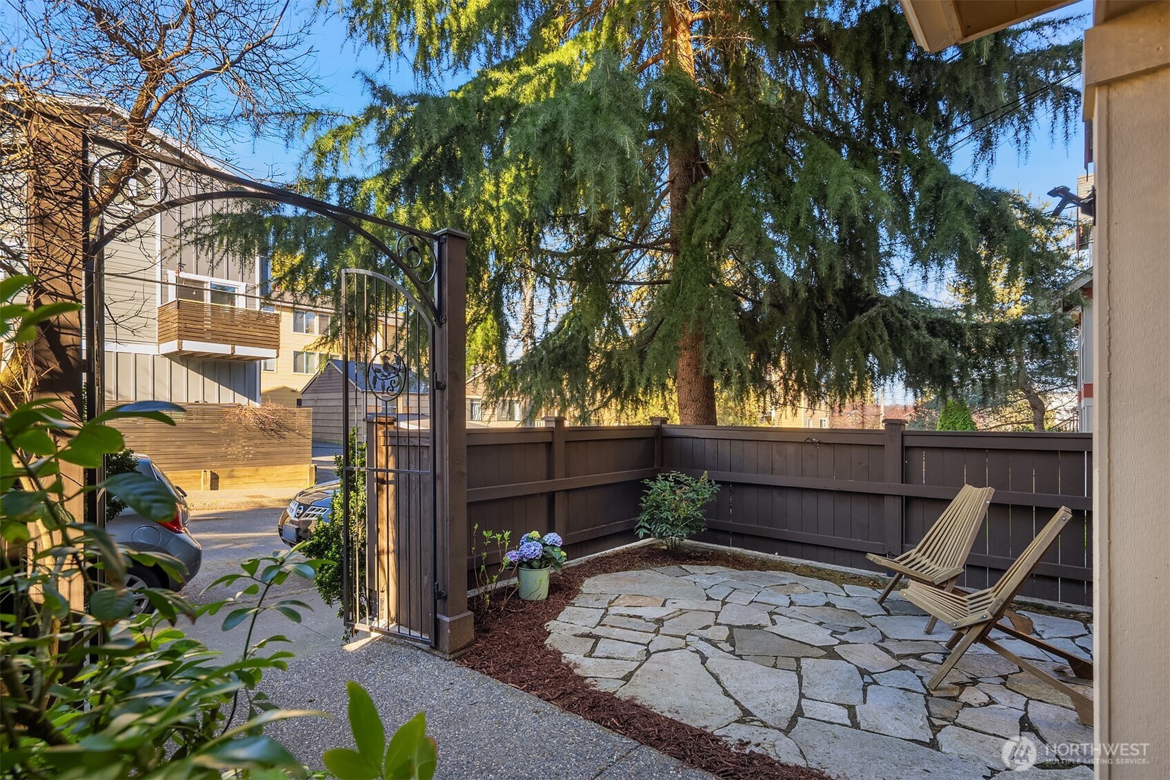 739 North 94th Street, Unit B Seattle, WA 98103 - Photo 27 of 39 a backyard of a house with table and chairs under an umbrella