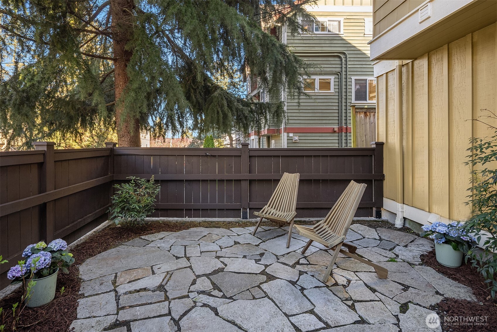739 North 94th Street, Unit B Seattle, WA 98103 - Photo 31 of 39 a view of backyard with a table and chair and wooden fence