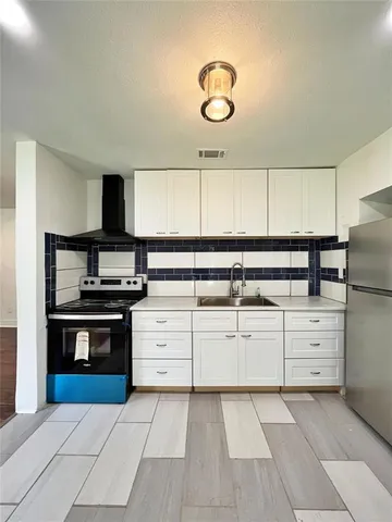 a kitchen with granite countertop a stove and a sink