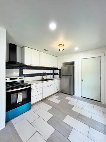 a kitchen with stainless steel appliances granite countertop a stove a sink and a refrigerator