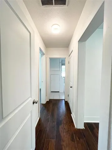 a view of a hallway with wooden floor