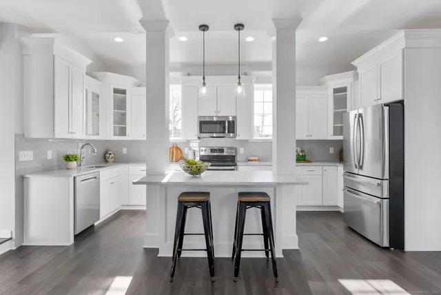 a kitchen with cabinets stainless steel appliances a sink and a window
