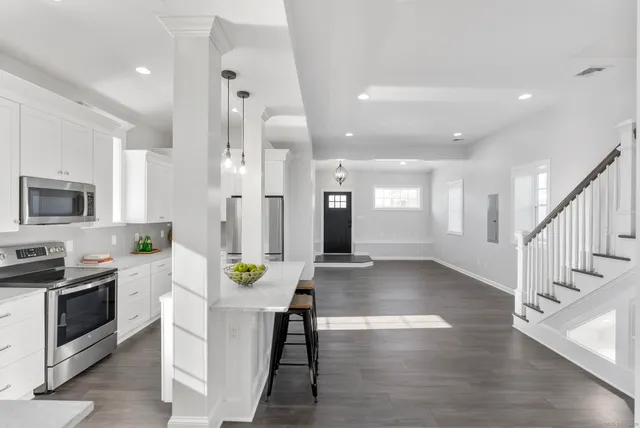 a view of an empty room with wooden floor and closet