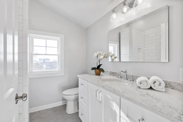 a bathroom with a granite countertop sink a toilet and bathtub