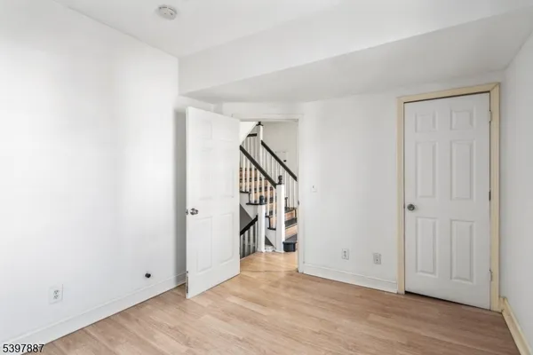a view of an empty room with wooden floor and entryway