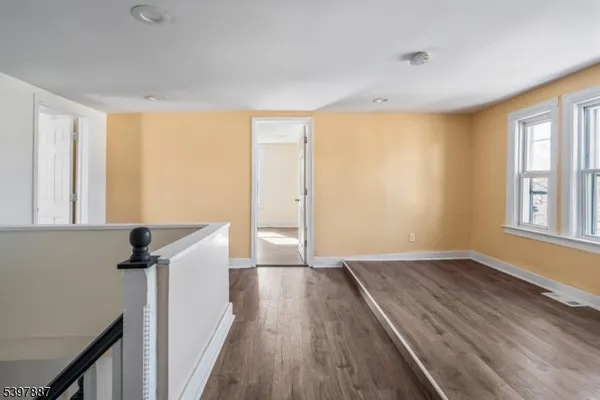 a view of hallway with a window and wooden floor