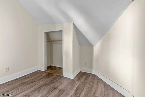 an empty room with wooden floor and closet