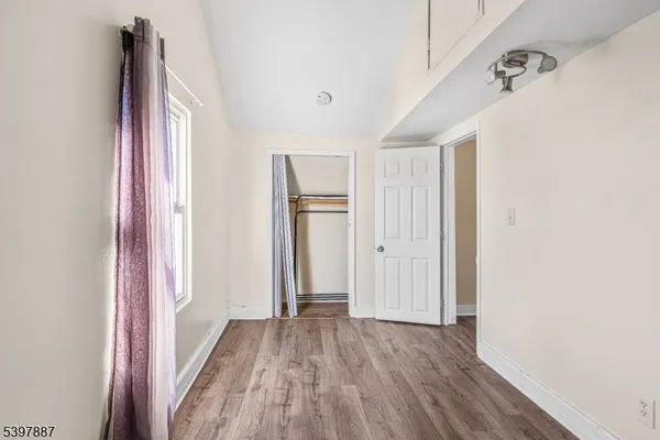 a view of a hallway with wooden floor and closet