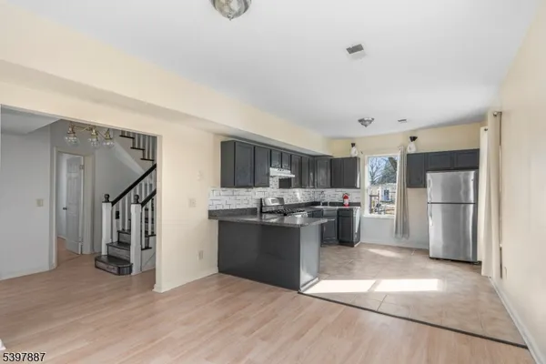 a kitchen with stainless steel appliances kitchen island wooden cabinets and refrigerator