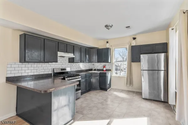 a kitchen with stainless steel appliances granite countertop a refrigerator stove microwave and sink