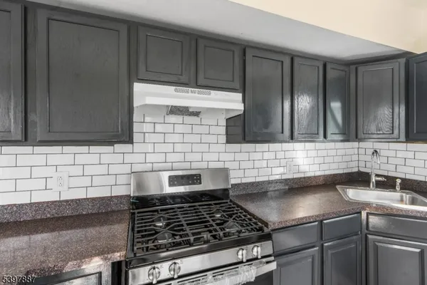 a kitchen with granite countertop a sink stainless steel appliances and cabinets