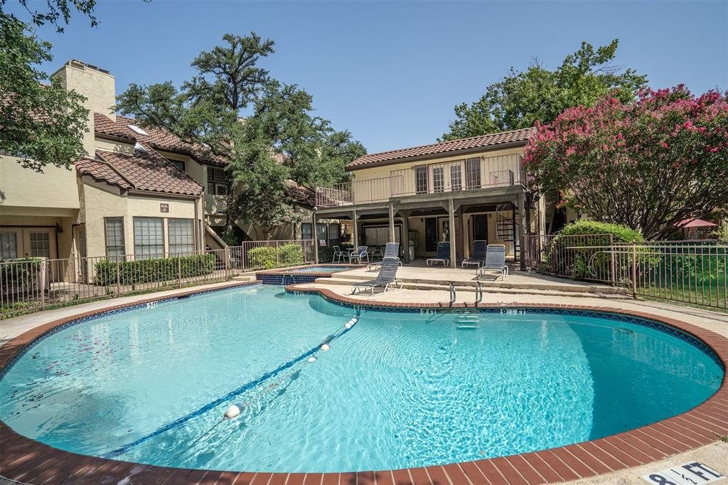 5590 Spring Valley Road, Unit H 203 Dallas, TX 75254 - Photo 3 of 27 Resort-style swimming pool with brick coping, an adjacent spa, and a surrounding paved deck