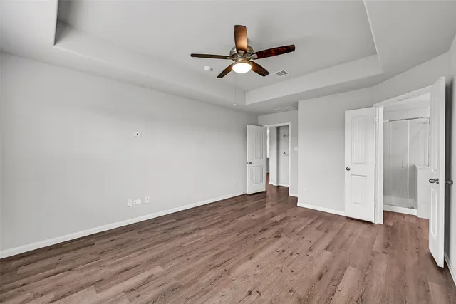 a view of empty room with wooden floor