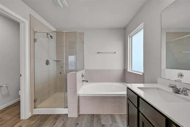 a bathroom with a tub sink shower and two mirror