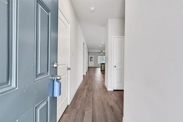 a view of a hallway with wooden floor and staircase