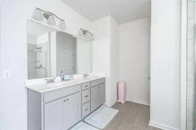 a spacious bathroom with a double vanity sink a mirror and a