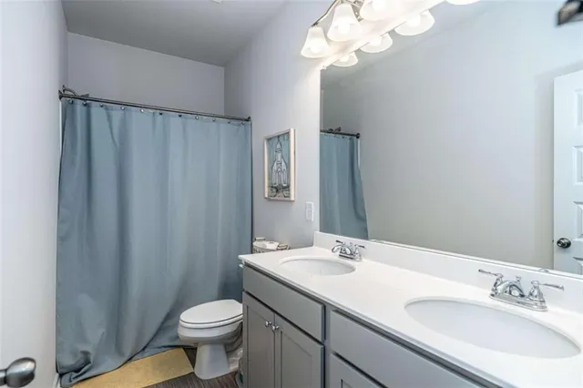 a bathroom with a sink a toilet and a mirror