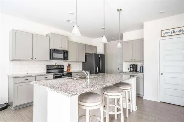 a kitchen with stainless steel appliances granite countertop a kitchen island a stove a table and chairs