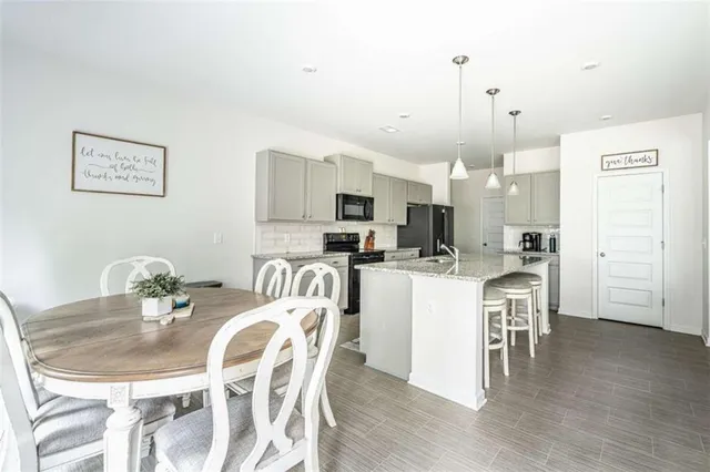 a kitchen with kitchen island granite countertop a sink cabinets and wooden floor