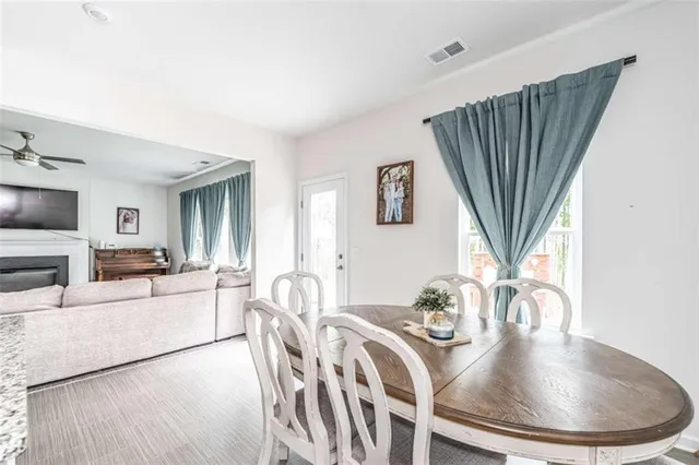 a dining room with furniture a fireplace and wooden floor