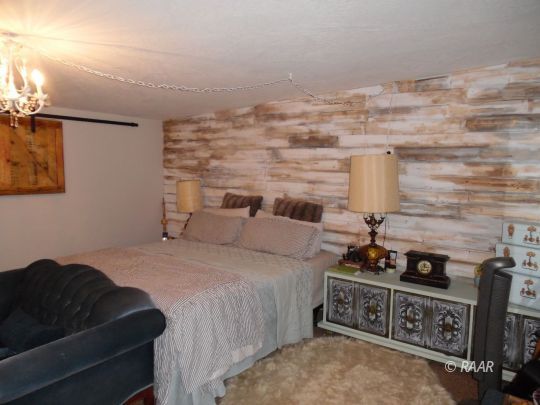 1355 South Mahan Street Ridgecrest, CA 93555 - Photo 14 of 35 a bedroom with a bed and wooden floor
