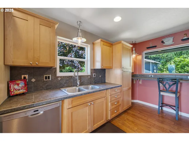 a kitchen with a sink a window and cabinets