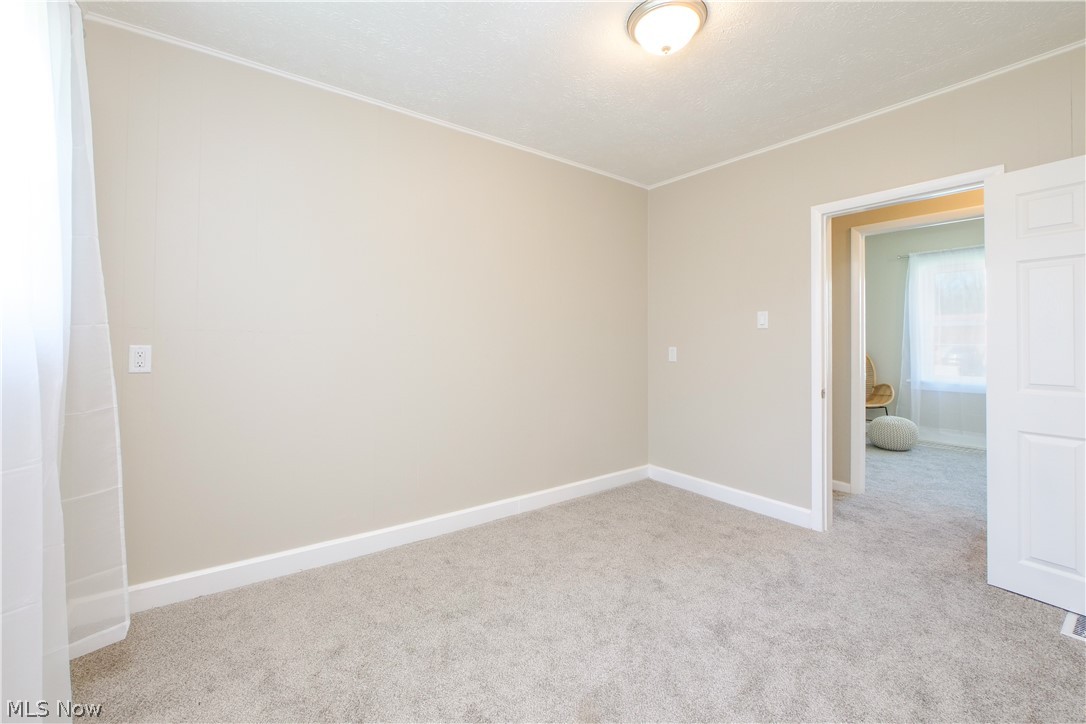 12379 Portage Street Rittman, OH 44270 - Photo 33 of 44 Carpeted empty room with crown molding