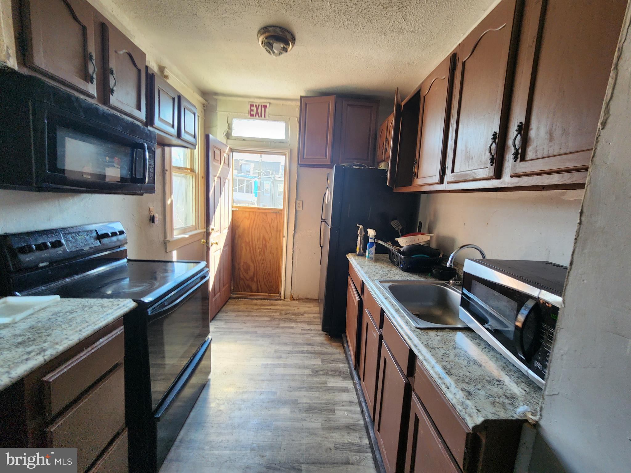 2217 Bryant Avenue Baltimore, MD 21217 - Photo 10 of 31 a kitchen with granite countertop stainless steel appliances and wooden cabinets