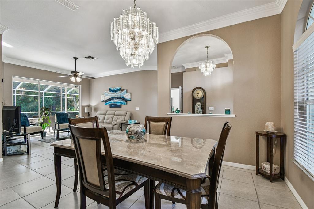 1955 Dunloe Circle Dunedin, FL 34698 - Photo 16 of 94 a dining room with furniture a chandelier and wooden floor