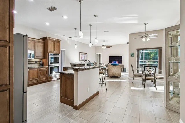 a view of a dining room and livingroom with furniture wooden floor a chandelier