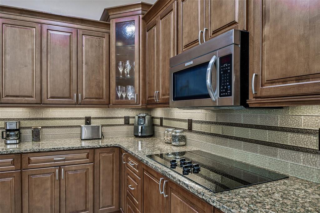 1955 Dunloe Circle Dunedin, FL 34698 - Photo 24 of 94 a kitchen with stainless steel appliances granite countertop a sink stove and cabinets