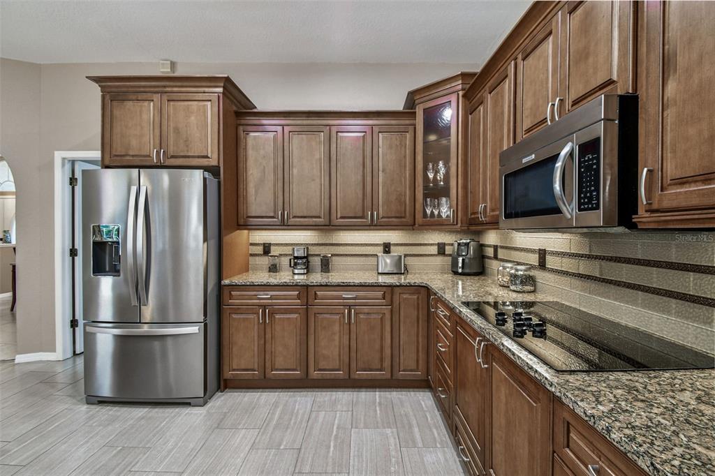 1955 Dunloe Circle Dunedin, FL 34698 - Photo 25 of 94 a kitchen with stainless steel appliances granite countertop a refrigerator stove and sink