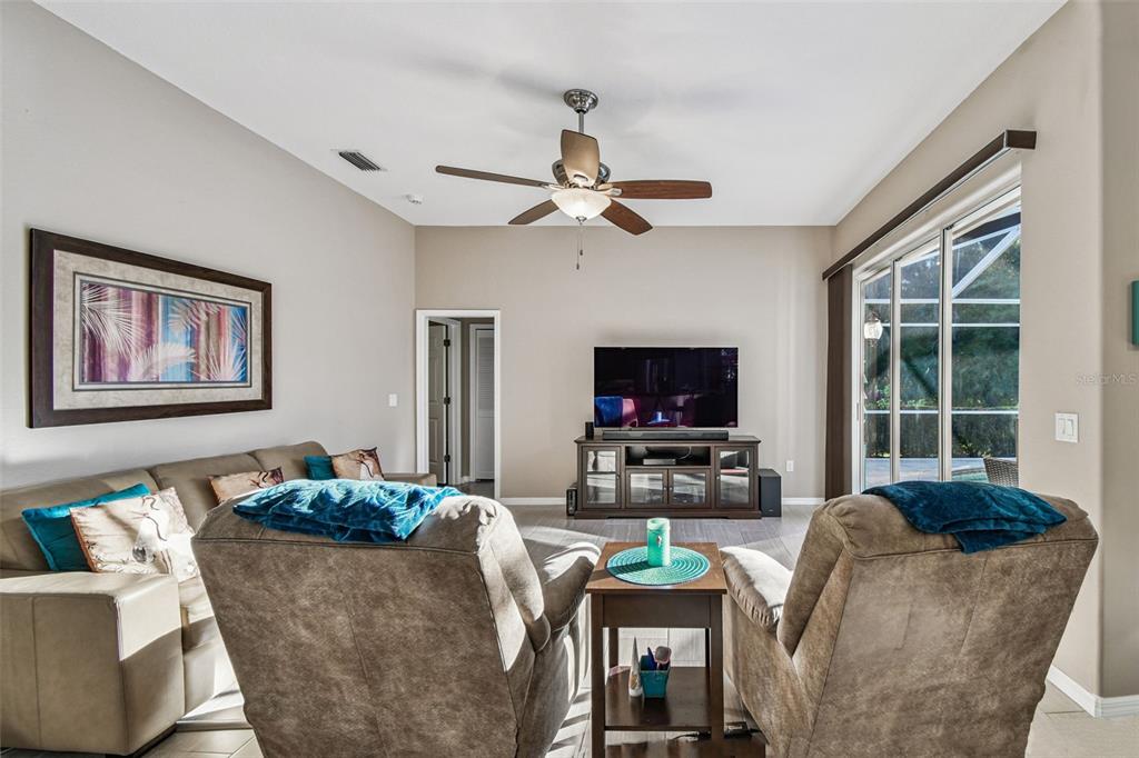 1955 Dunloe Circle Dunedin, FL 34698 - Photo 32 of 94 a living room with furniture a flat screen tv and a window