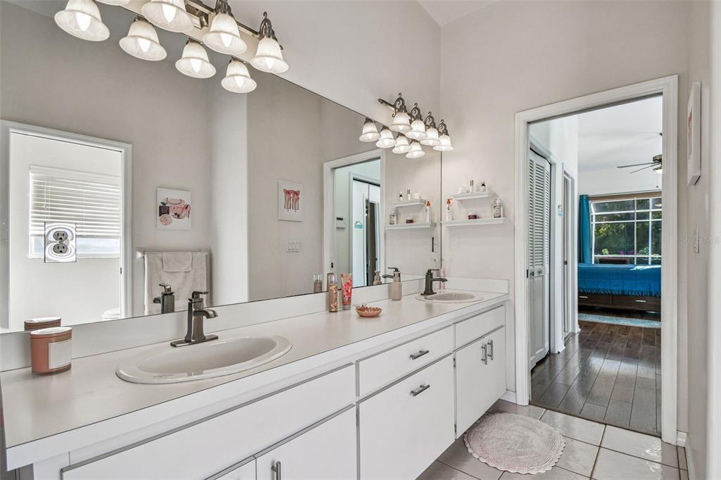 1955 Dunloe Circle Dunedin, FL 34698 - Photo 43 of 94 a bathroom with a double vanity sink and a mirror