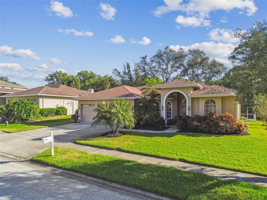 1955 Dunloe Circle Dunedin, FL 34698 - Photo 78 of 94 a front view of a house with a yard and garage