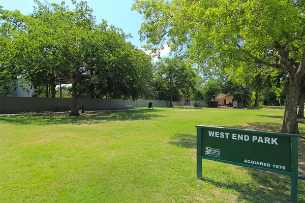 a view of a park with a bench and trees