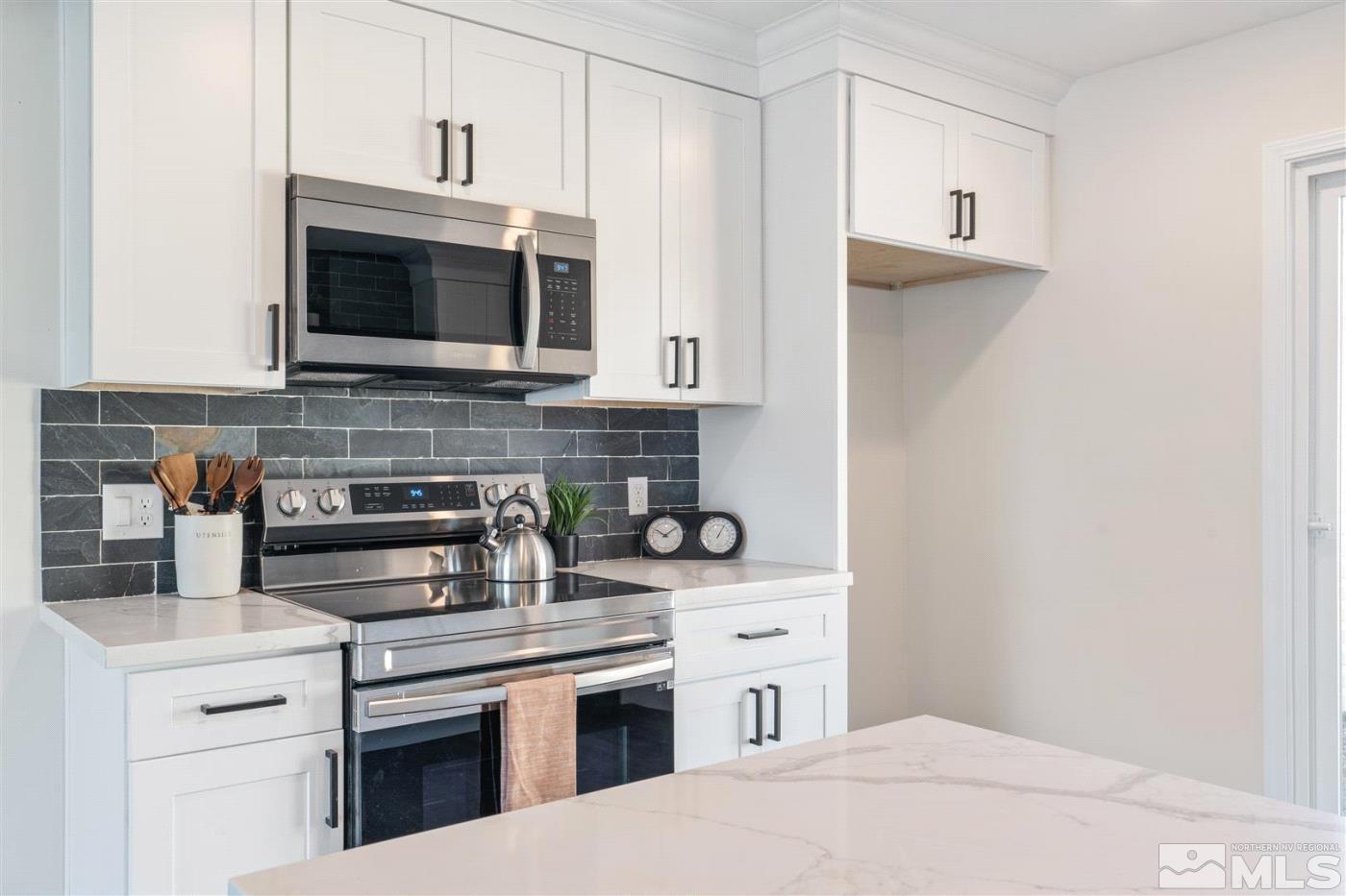 289 Bartlett Street Reno, NV 89512 - Photo 11 of 40 a kitchen with stainless steel appliances a stove microwave and cabinets