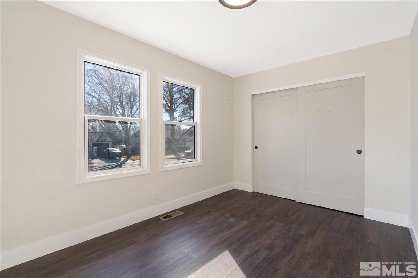 289 Bartlett Street Reno, NV 89512 - Photo 21 of 40 an empty room with wooden floor and windows
