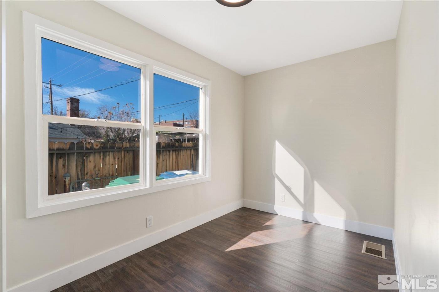 289 Bartlett Street Reno, NV 89512 - Photo 24 of 40 a view of an empty room with a window and wooden floor